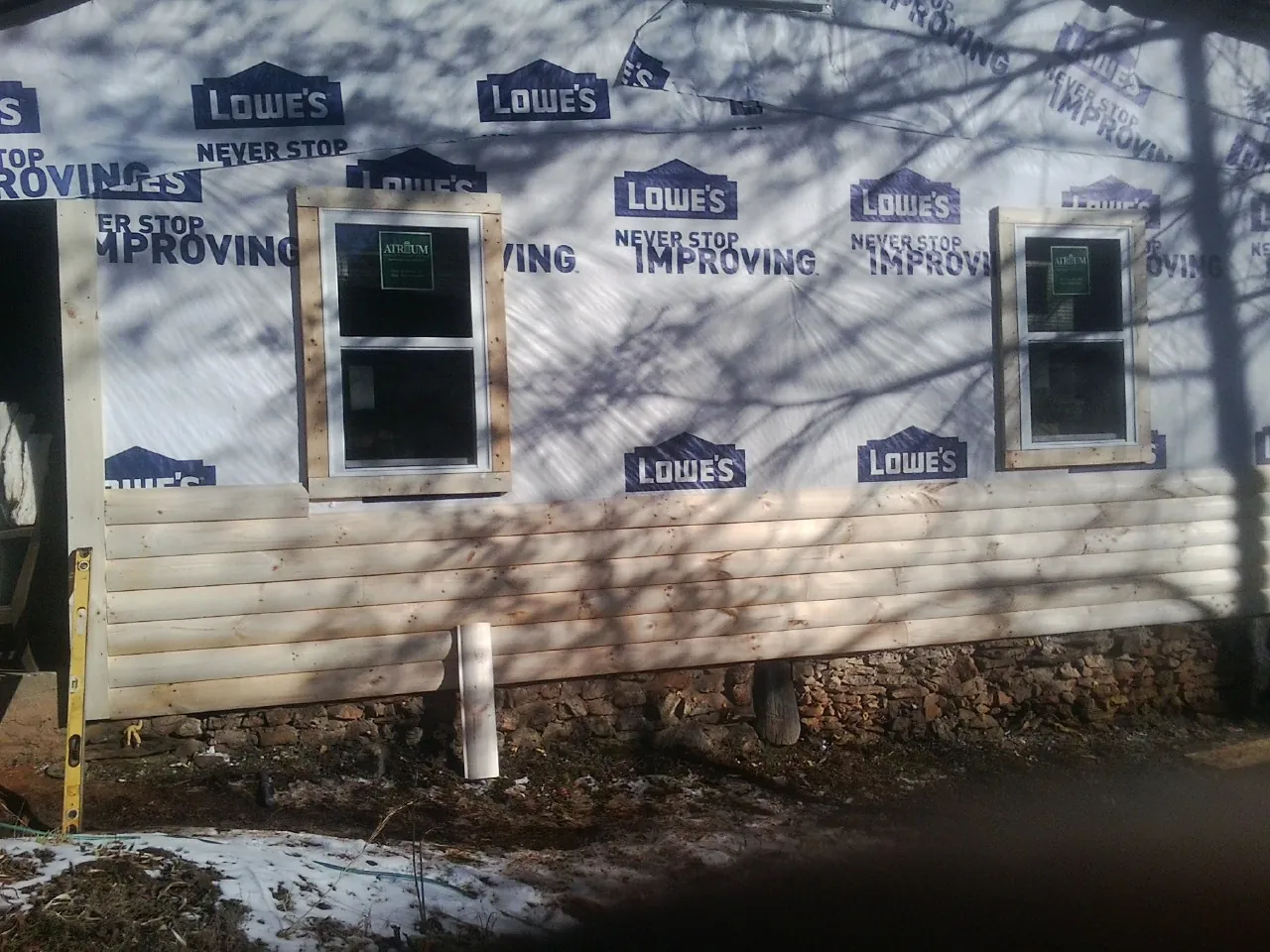 House wrap and new log siding going up on an exterior wall in Winchester