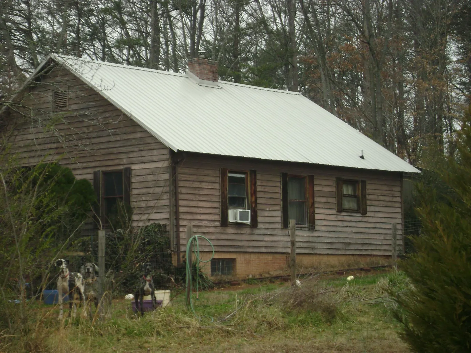 White metal roof on an old wood sided farmhouse, from a Metal Roof Installation job in Winchester